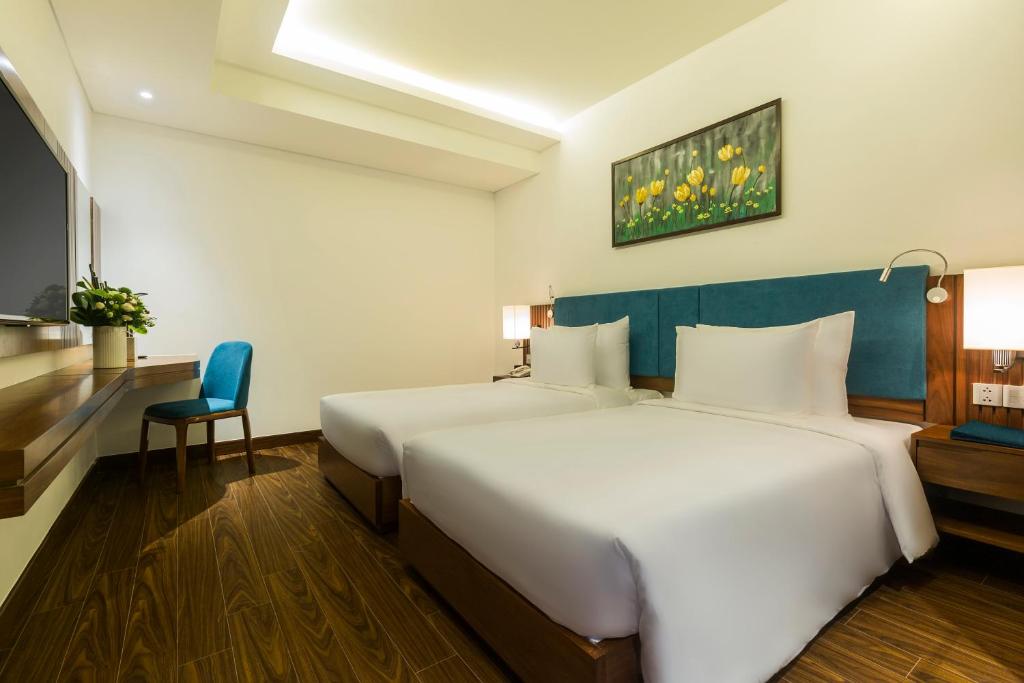 Postel nebo postele na pokoji v ubytování Maximilan Danang Beach Hotel