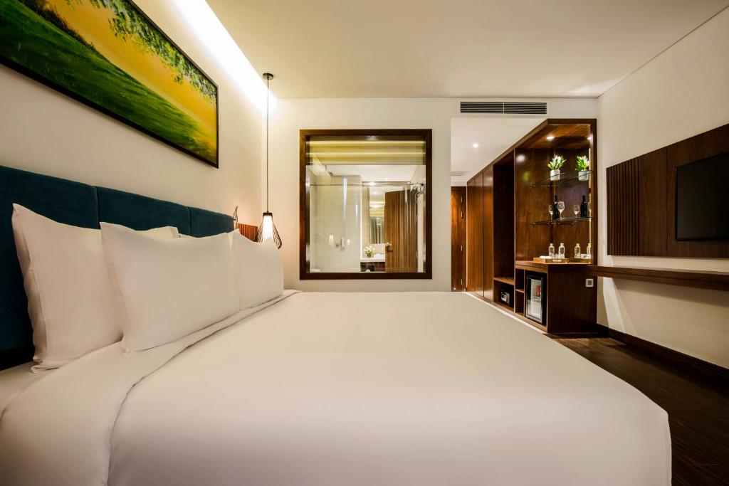 Postel nebo postele na pokoji v ubytování Maximilan Danang Beach Hotel