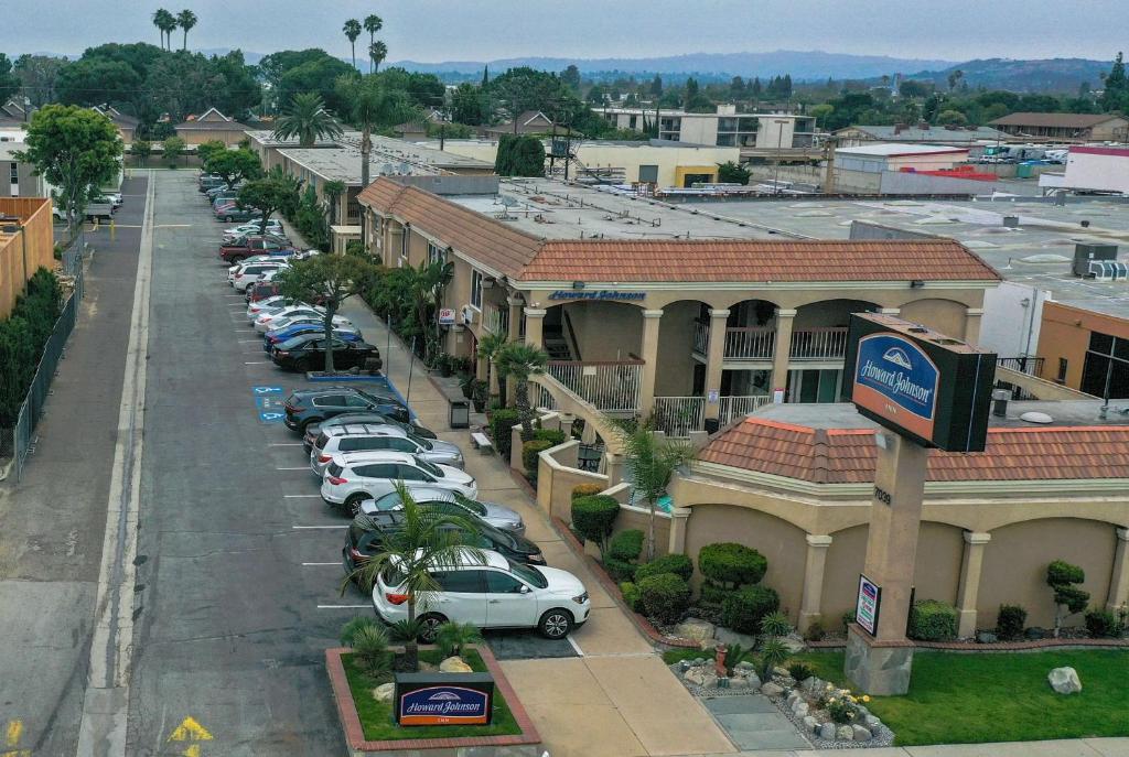 een stadsstraat met auto's geparkeerd op een parkeerplaats bij Howard Johnson by Wyndham Buena Park in Buena Park