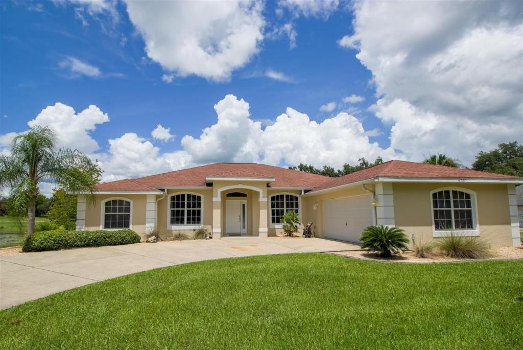 a large house with a green lawn at Luxury 4BR Pool Home with Jacuzzi- Inverness in Inverness