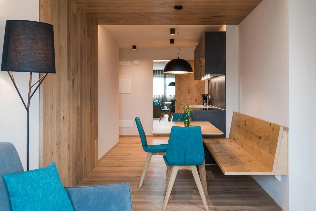 - une salle à manger et une cuisine avec une table et des chaises dans l'établissement Aparthotel Abiná Lana Höhe, à Lana