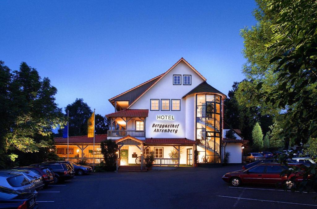 ein Hotel mit Autos auf einem Parkplatz in der Unterkunft Romantik Hotel Ahrenberg in Bad Sooden-Allendorf