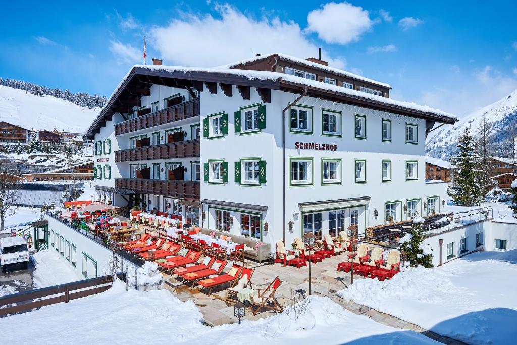 レッヒにあるBoutique-Hotel Schmelzhofの雪の中にテーブルと椅子を配置したホテル