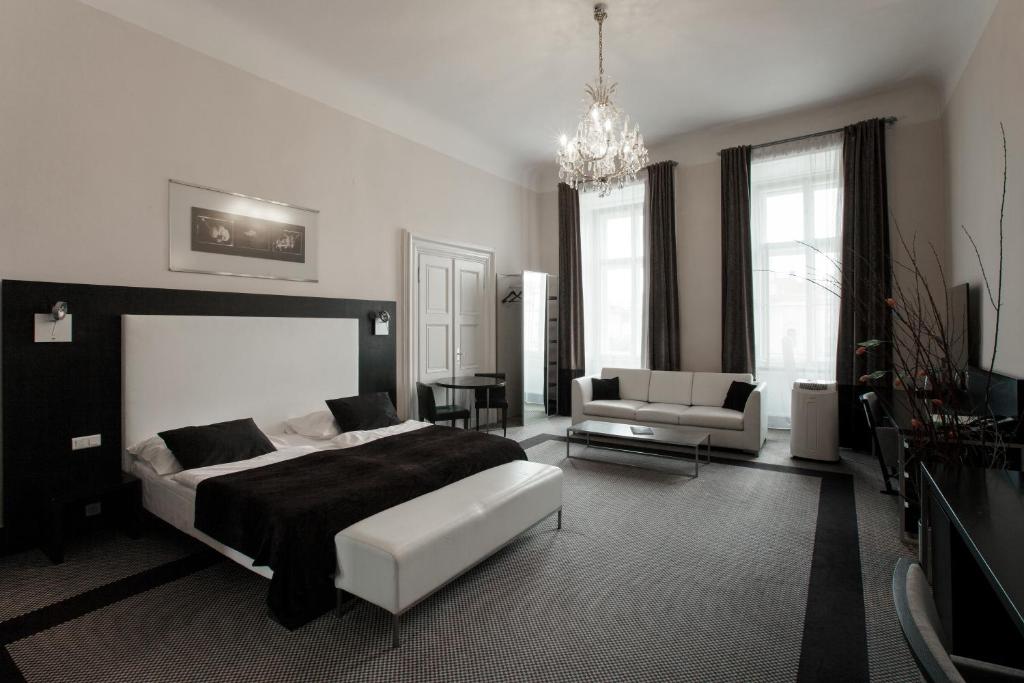 czarno-biała sypialnia z łóżkiem i kanapą w obiekcie Old Town Square Residence by Emblem w Pradze