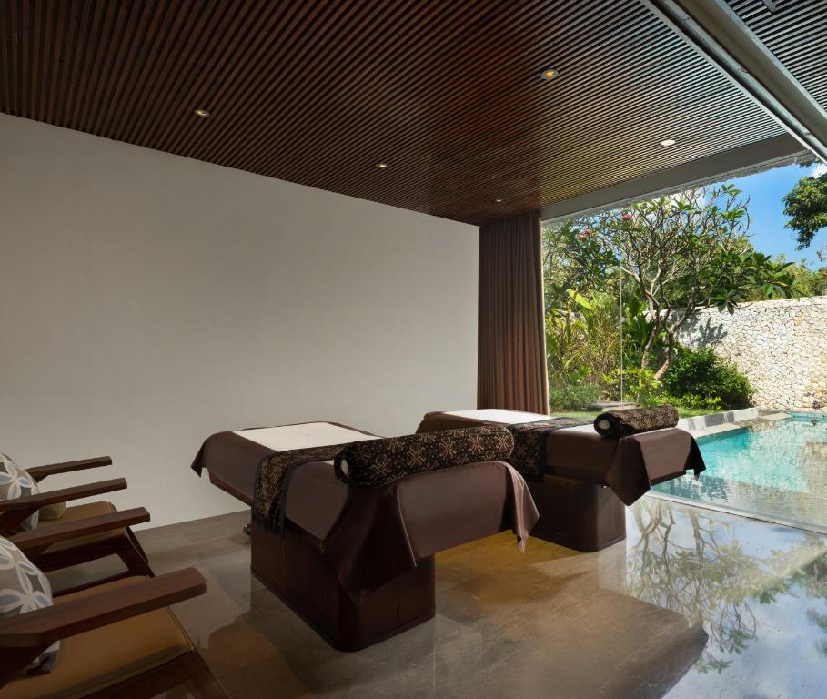 a room with two beds and a swimming pool at Anantara Uluwatu Bali Resort in Uluwatu