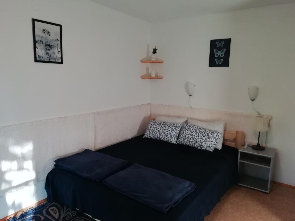 una camera da letto con letto con lenzuola e cuscini blu di Azúr apartman a Harkány
