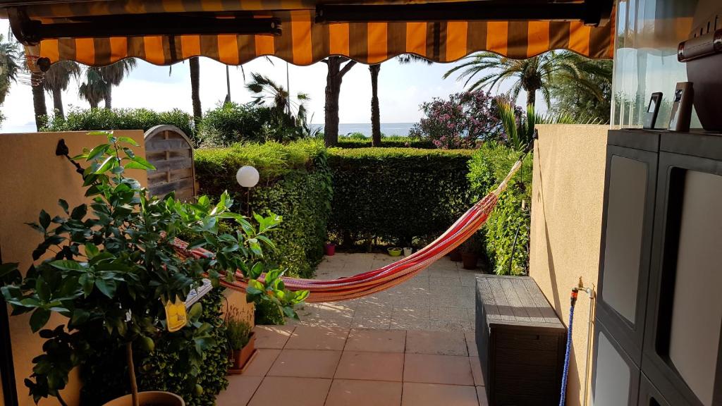 a hammock in the middle of a patio with plants at T2 rez de jardin front de mer in Cannes