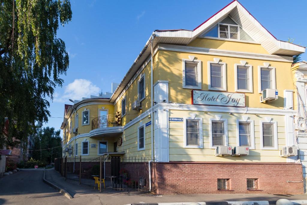 a yellow building with a sign that reads home city at Joy Hotel in Nizhny Novgorod