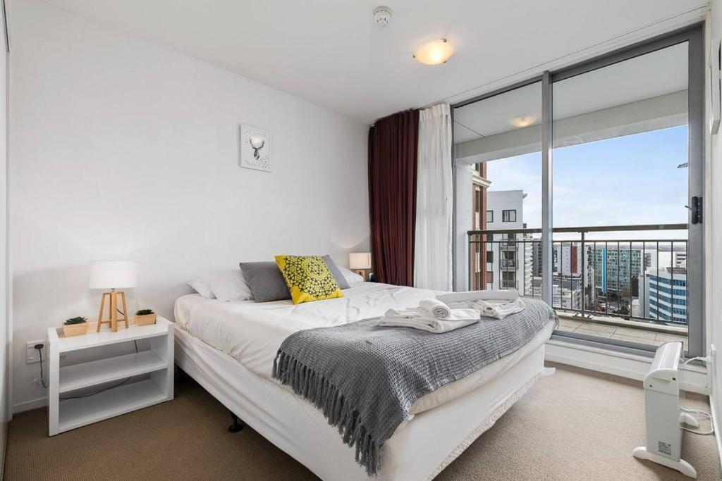 a bedroom with a bed and a large window at Wonderful Apartment in Quiet CBD Neighbourhood! in Auckland