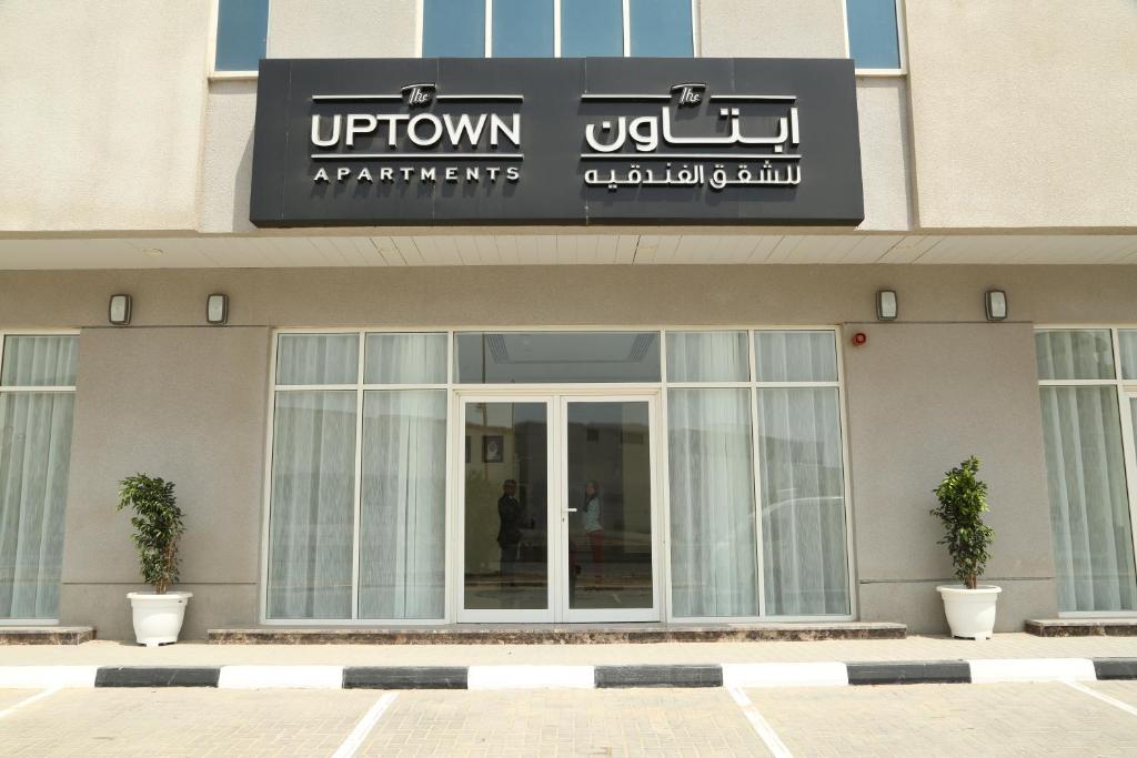 Uptown Hotel Apartment Fujairah By Gewan في الفجيرة: مبنى عليه لافته تقرأ الشقق العلويه