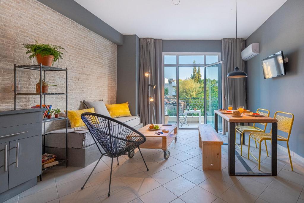 Boutique Studios & Apartments - by Avelink في سباتا: غرفة معيشة مع أريكة وطاولة