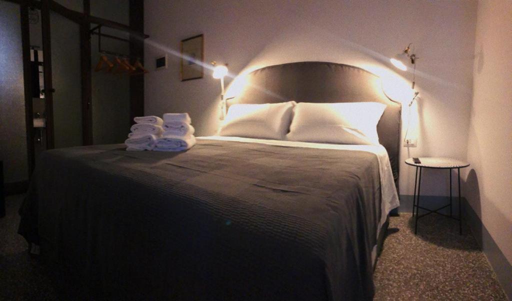een slaapkamer met een groot bed met witte lakens en kussens bij Torre Tresca 2 in Bari