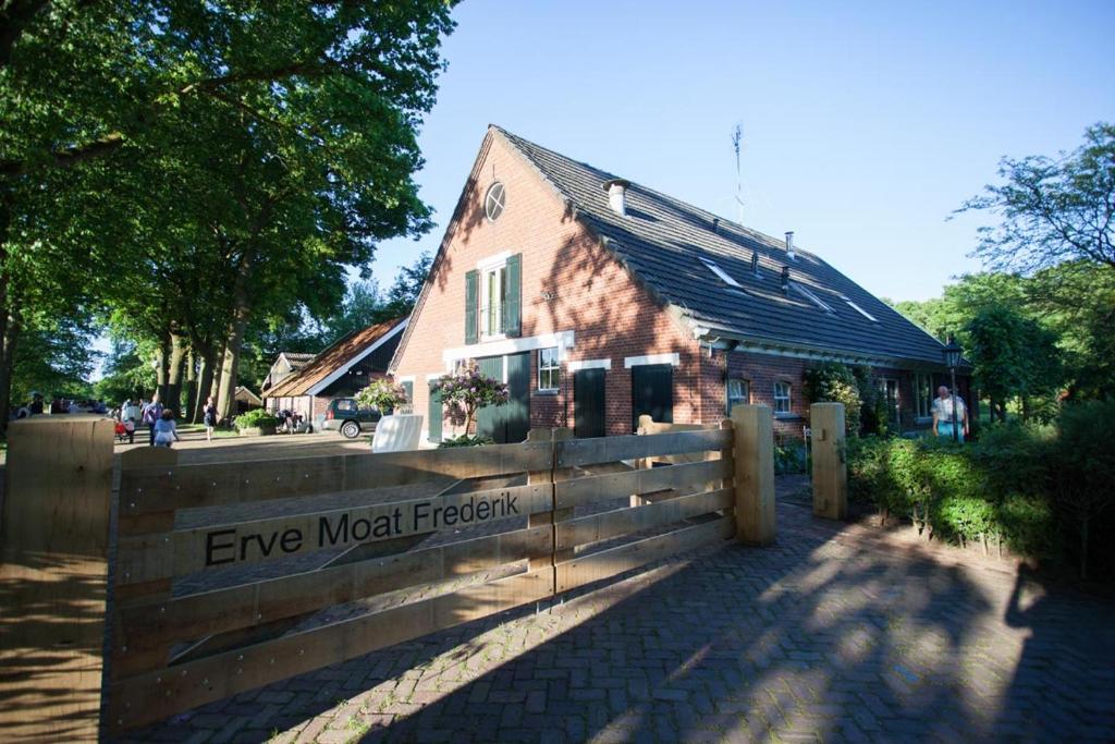 ein Gebäude mit einem Holzzaun vor einem Gebäude in der Unterkunft Appartement de Voshaar in Enschede