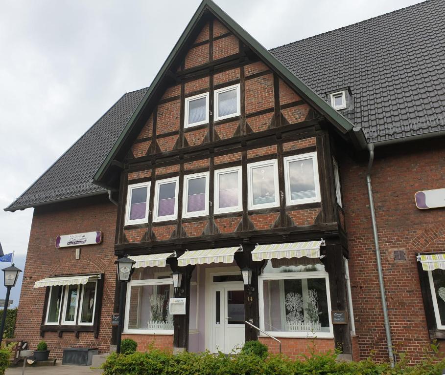 una casa con ventanas blancas y techo negro en Hotel Stadt Boizenburg en Boizenburg