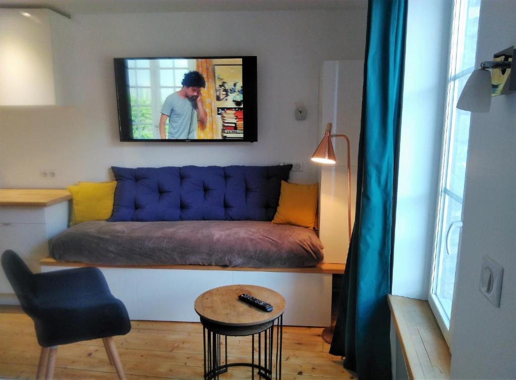 een woonkamer met een bank en een stoel bij L' établissement APPARTEMENTS DESIGN , vous propose 4 appartements neufs avec services , NETFLIX , lits faits à votre arrivée , serviettes de toilette , ménage, Wifi , en hyper centre , Vue mer à 200m , BOX à Vélos sur demande in Dieppe