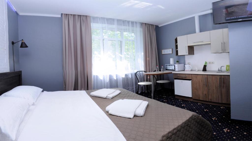 1 Schlafzimmer mit einem großen weißen Bett und einer Küche in der Unterkunft Luxury.ap in Iwano-Frankiwsk