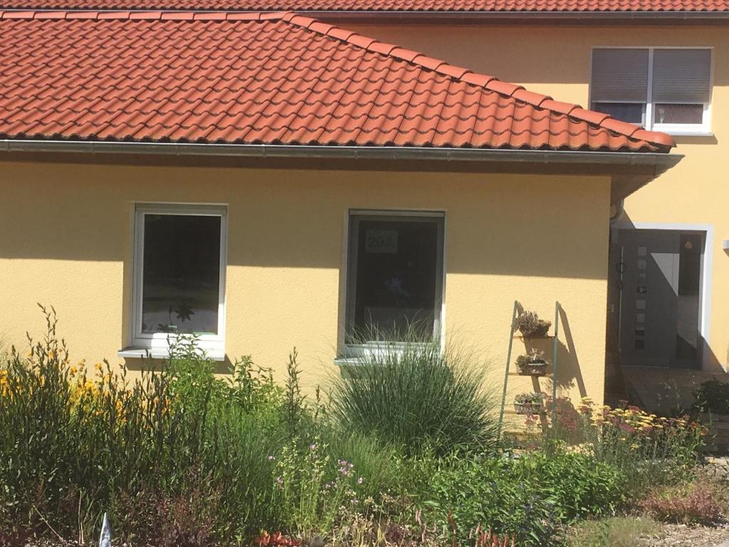 una casa amarilla con techo naranja en Ferienwohnung Walkershofen, en Simmershofen