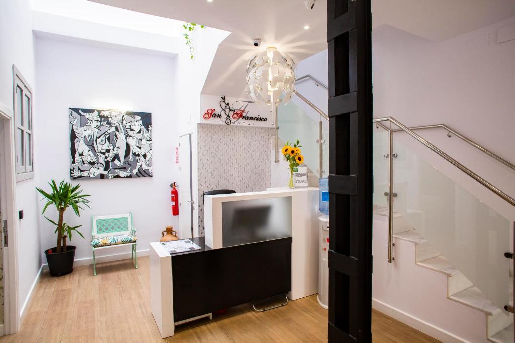 - un salon avec une télévision et un escalier dans l'établissement Hostal San Francisco, à Séville