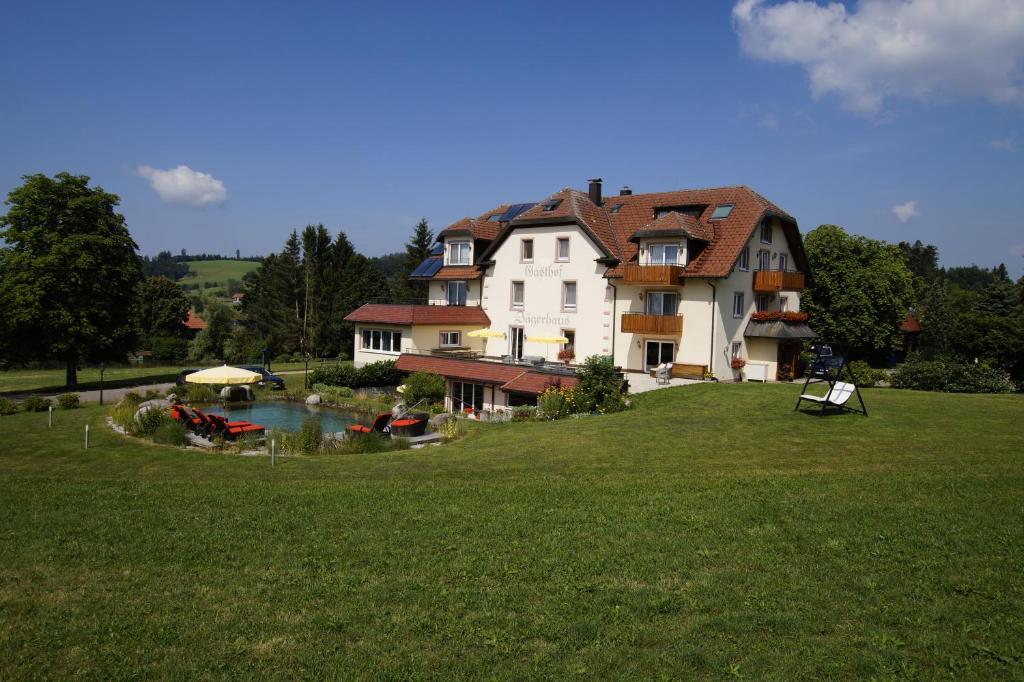 une grande maison avec un lac en face de celle-ci dans l'établissement Hotel Gasthof Jägerhaus, à St. Peter