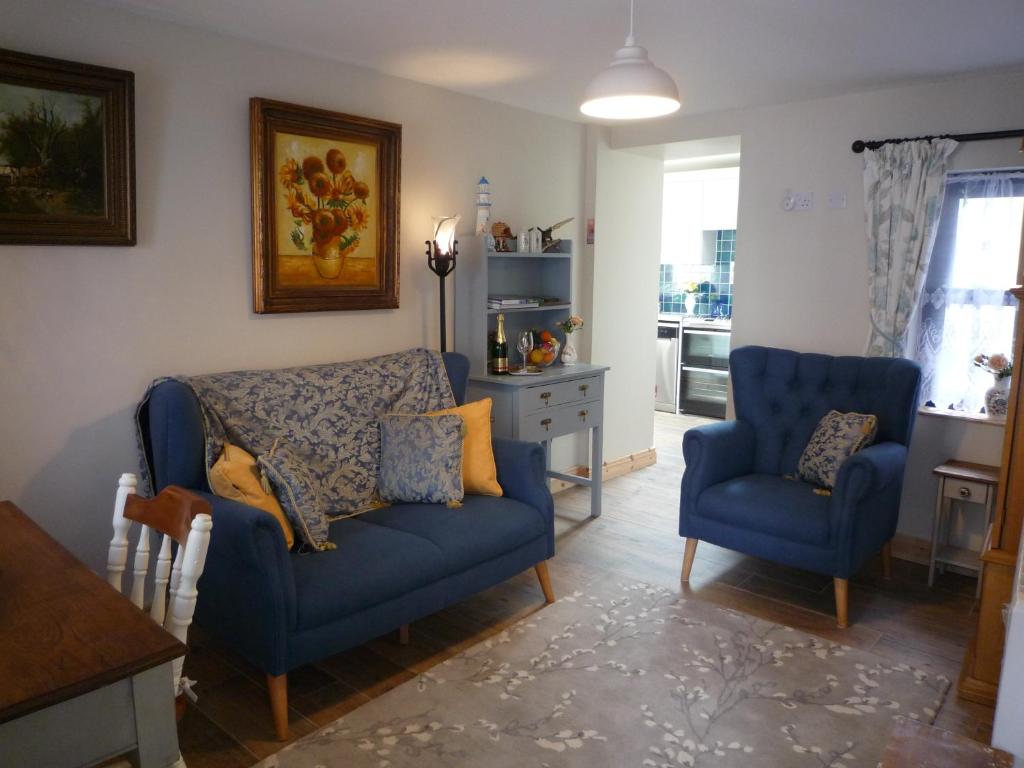een woonkamer met twee blauwe stoelen en een tafel bij Kitty's in Tullamore