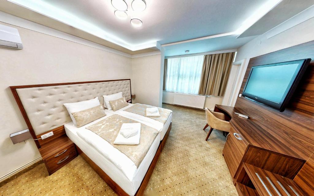 um quarto de hotel com uma cama e uma televisão de ecrã plano em Hotel Turist 98 em Jajce