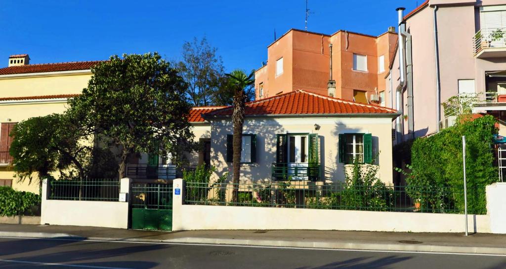 a white house with a fence on a street at Villa Nada in Zadar