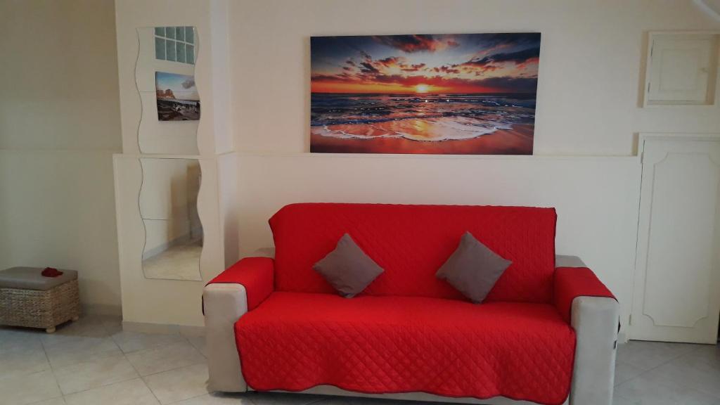een rode stoel in een kamer met een schilderij aan de muur bij Profumo di Mare (Sea's Perfume) in Giovinazzo