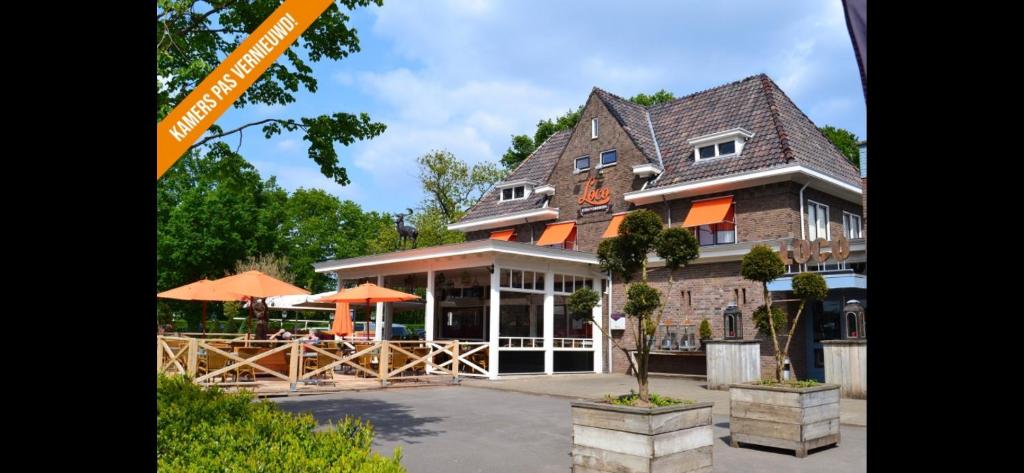 un grand bâtiment avec des parasols en face de celui-ci dans l'établissement Hotel Loco, à Lievelde