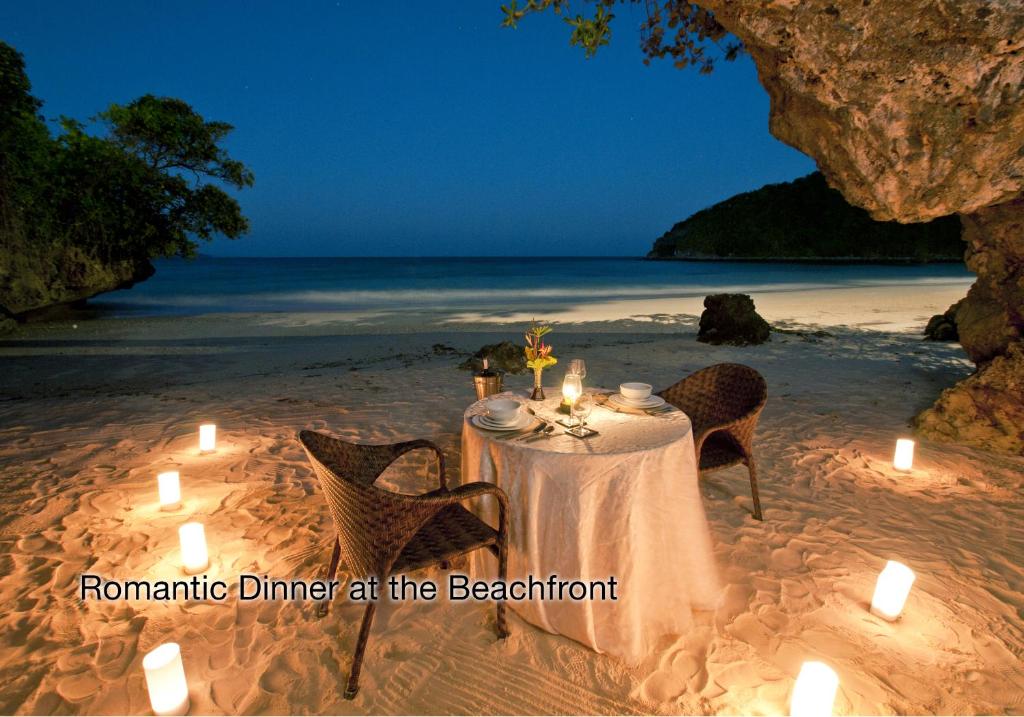 a dinner table on the beach with candles at Fairways and Bluewater Boracay in Boracay
