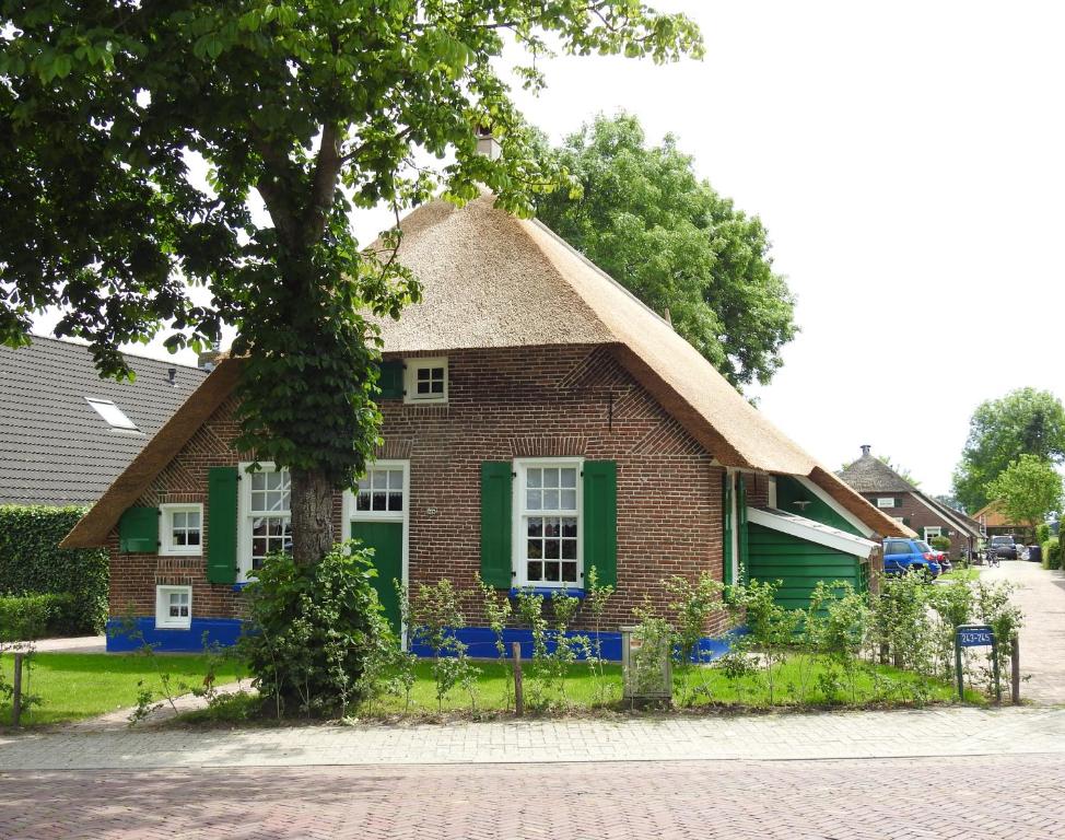 a small brick house with a green window at Vakantiehuis An Diek in Staphorst