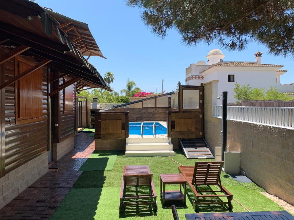 a backyard with chairs and a swimming pool at Wood House Close Beach in Marbella
