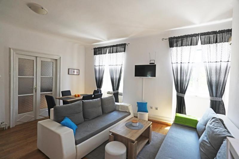 ein Wohnzimmer mit einem Sofa und einem Tisch in der Unterkunft ODEON Apartment And Rooms in Rijeka