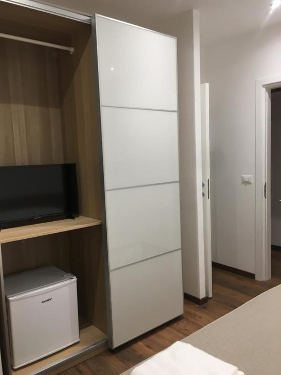szafa z białymi szufladami i telewizorem w obiekcie Il Faro Gianicolense w Rzymie