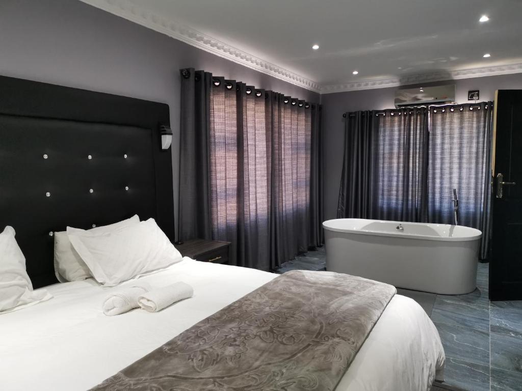 a bedroom with a large bed and a bath tub at The Green Olive Guesthouse in Bethlehem