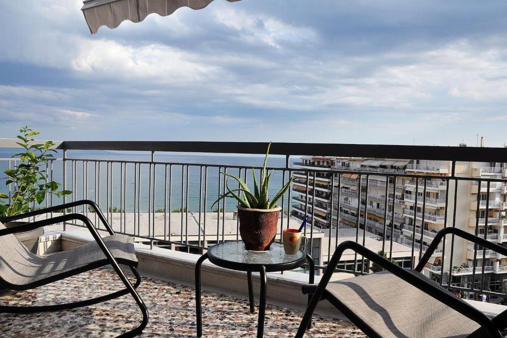 a patio with a table and chairs on a balcony at Unique flat of refined luxury and splendid views. in Kavala