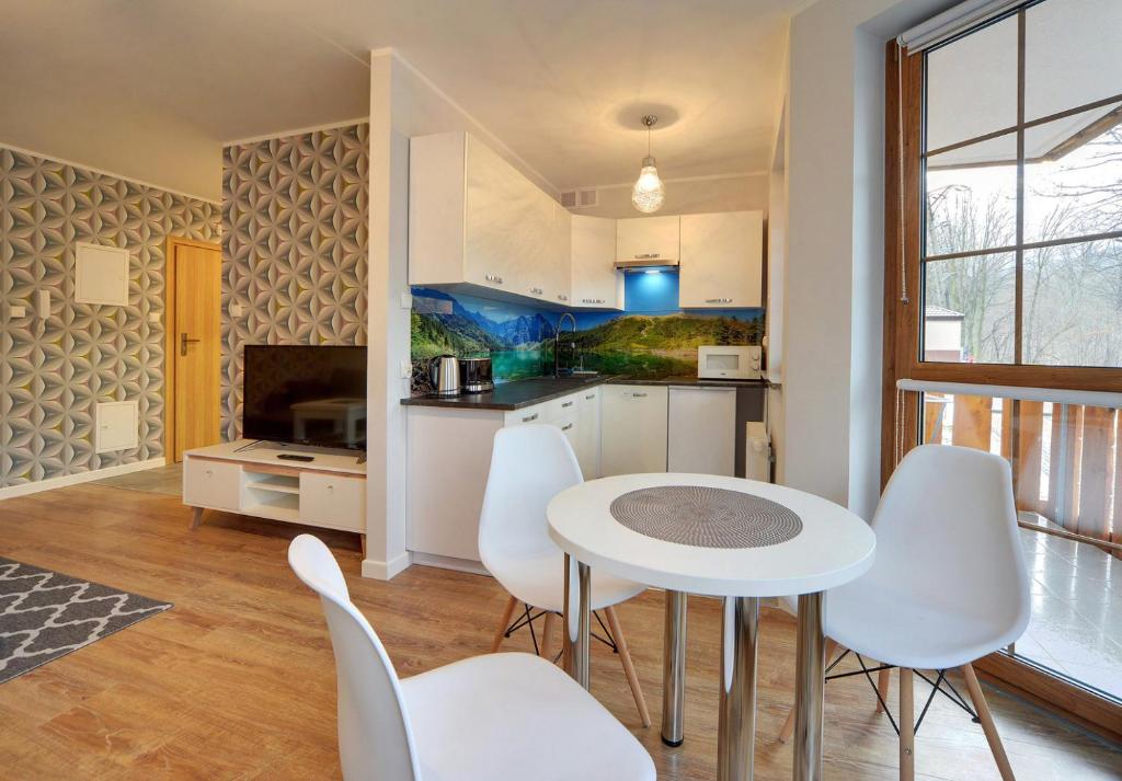 Televízia a/alebo spoločenská miestnosť v ubytovaní Apartamenty EverySky - Leśny Dom 16 - 18