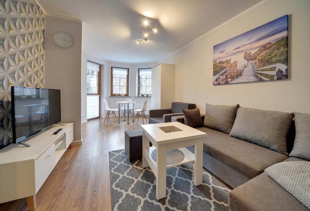 Televízia a/alebo spoločenská miestnosť v ubytovaní Apartamenty EverySky - Leśny Dom 16 - 18