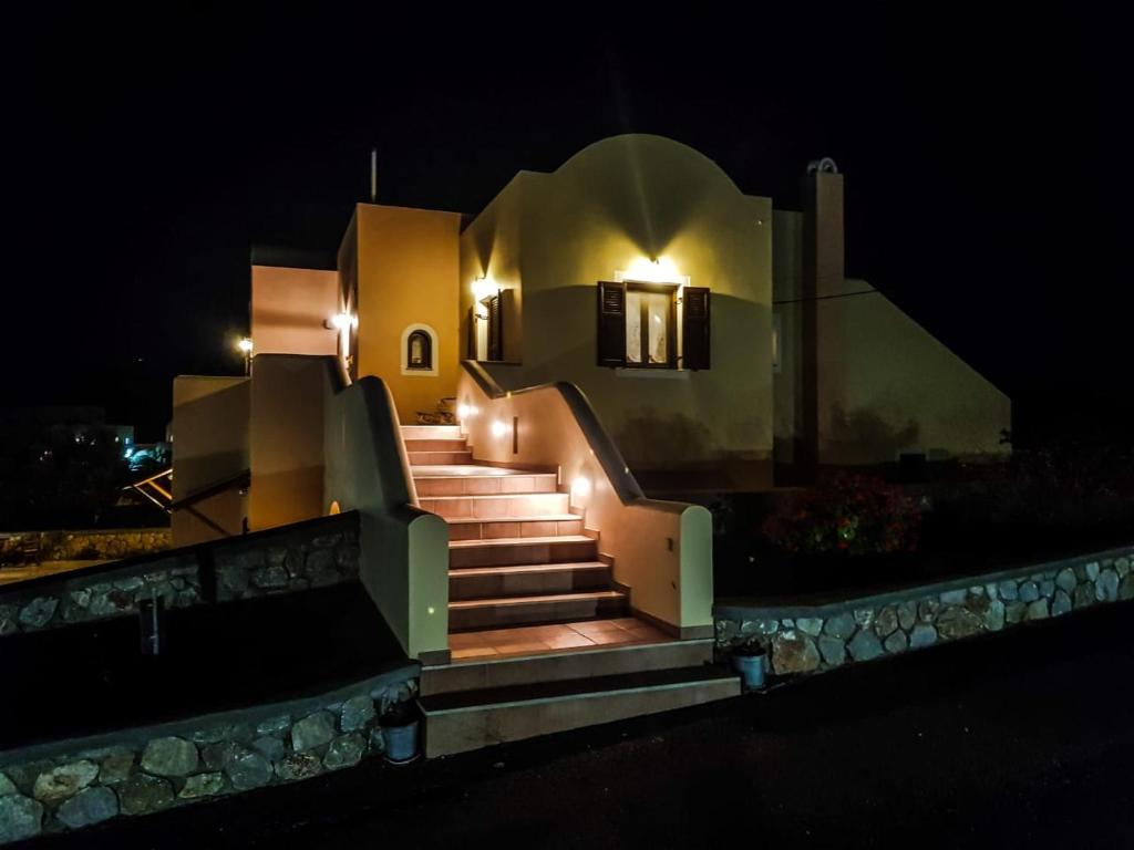 a set of stairs leading to a house at night at Sunshine house for 9, cozy set up,verandas, sea view. in Karterados