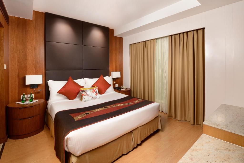a hotel room with a large bed with red pillows at Svelte Delhi, a member of Radisson Individuals in New Delhi