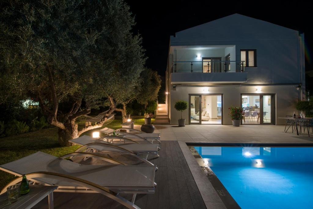 a villa with a swimming pool at night at Sunlight Breeze Villa in Chania Town