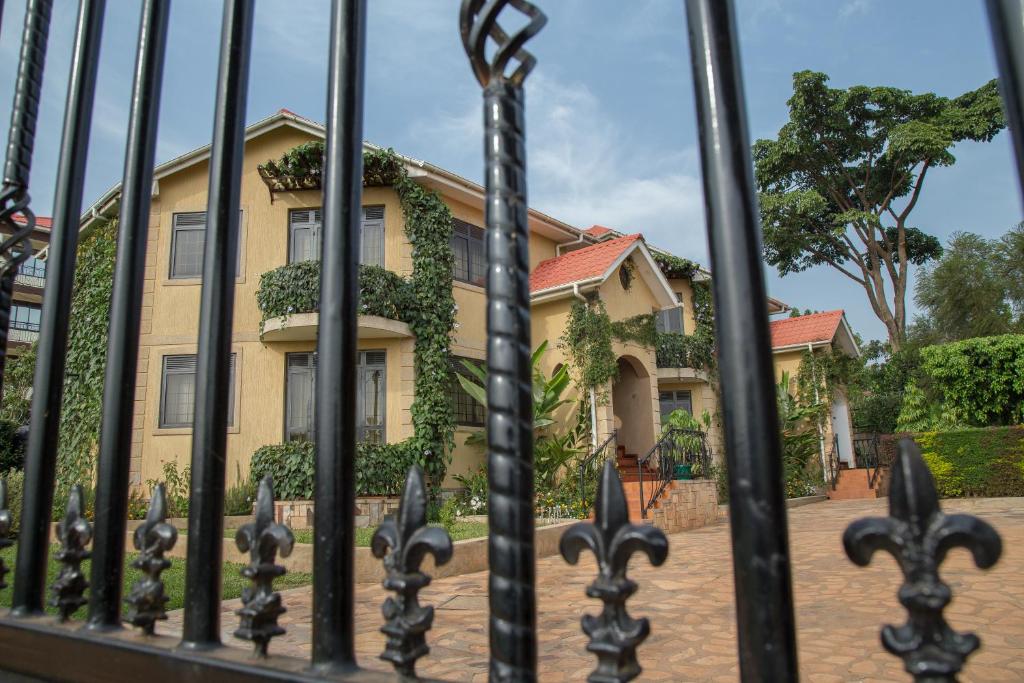 una casa amarilla con una valla delante de ella en Villa Karibu Serviced Apartments-Kampala, en Kampala