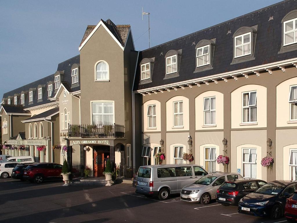 a large building with cars parked in a parking lot at Lady Gregory Hotel, Leisure Club & Beauty Rooms in Gort