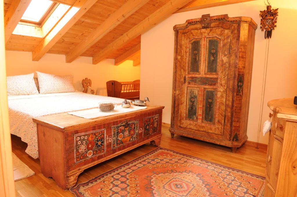 1 dormitorio con 1 cama y un gran armario de madera en La Casa Del Gelsomino, en Ospedaletto