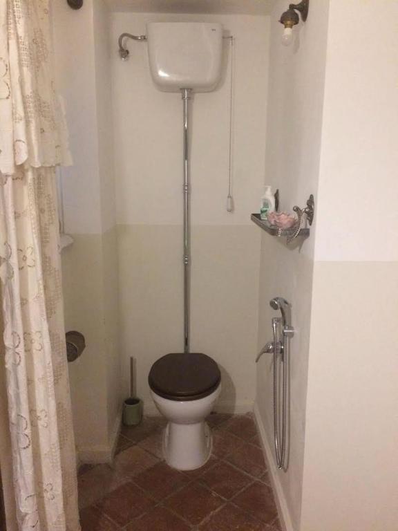 a bathroom with a toilet with a black seat at B&B del Giglio in Cefalù