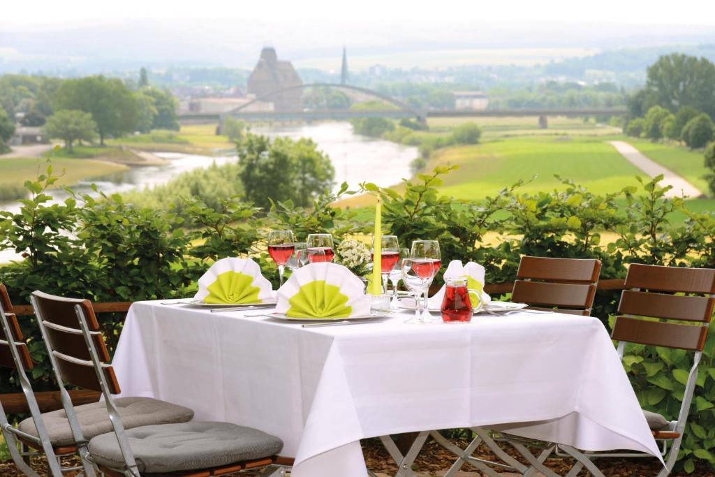 a table with wine glasses and a view of a river at Hotel Kiekenstein in Stahle