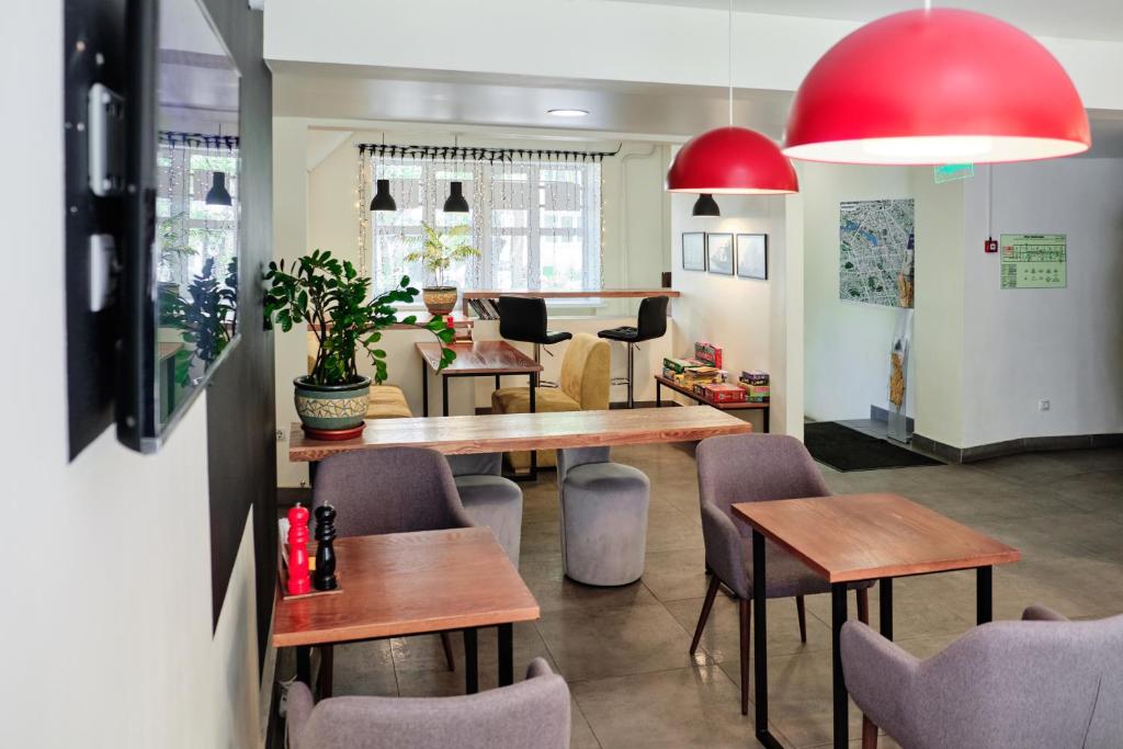 エカテリンブルクにあるDoBeDo Hotelの木製のテーブルと椅子、赤いランプが備わるレストラン
