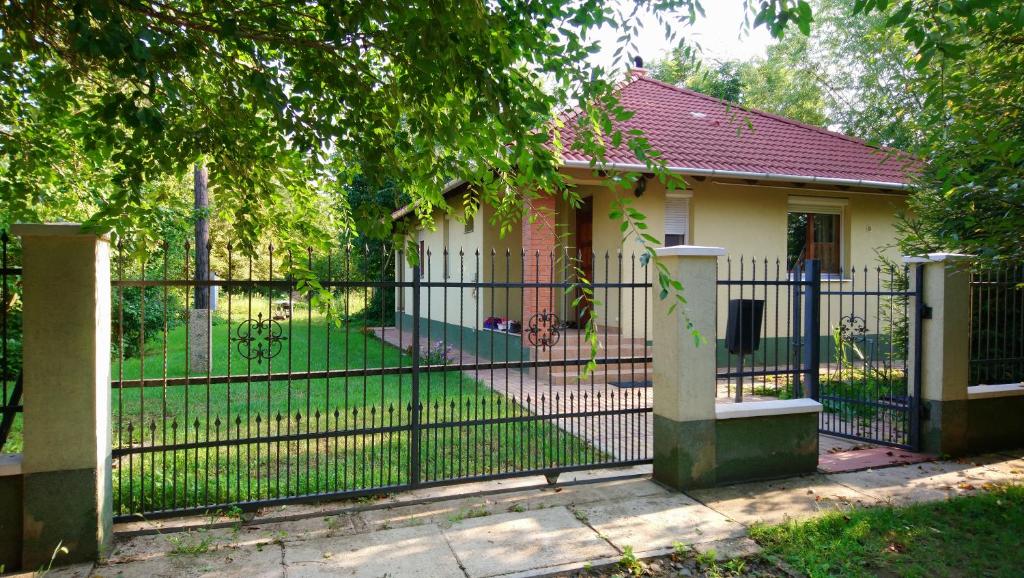 a black fence in front of a small house at Gyümölcsöskert Szálláshely in Debrecen