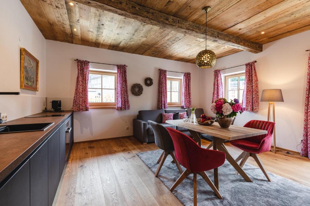 een keuken en een woonkamer met een tafel en stoelen bij Appartementhaus Plainstöckl Hotel Gasthof Maria Plain in Salzburg