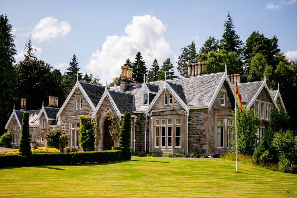 a large house with a green yard at Scatwell House in Garve