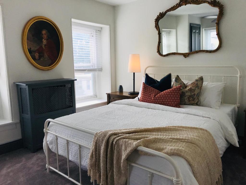 a bedroom with a bed and a mirror on the wall at Modern Parisian Apartment in the Heart of Manayunk in Philadelphia